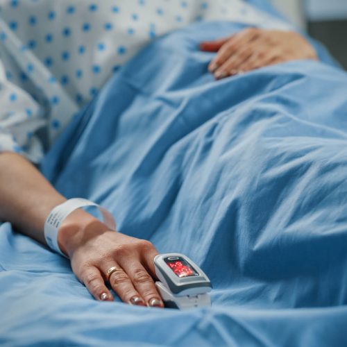 patient in hospital bed connected to medical equipment.